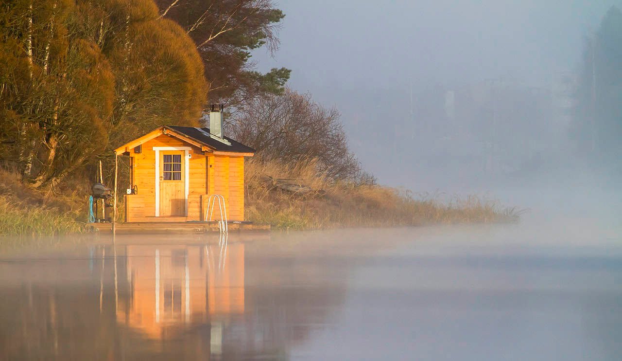 Eingang einer in den Hang eingelassenen Erdsauna aus Holz und Lehm
