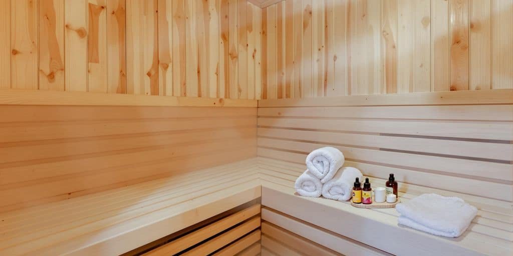 Holzbänke einer Heimsauna mit Reinigungsbürste und Eimer